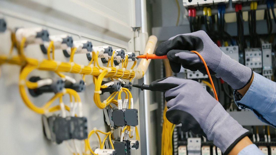 Técnico medindo a fiação de um quadro elétrico